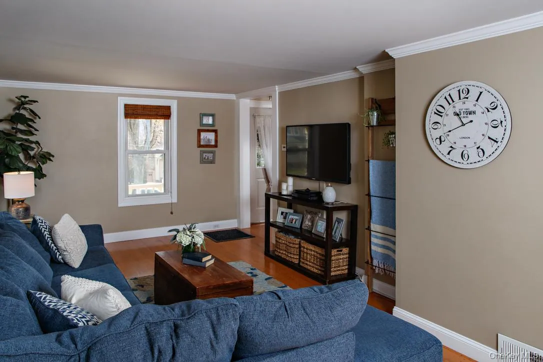 Living area with crown molding and wood finished floors Living area with crown molding and wood finished floors
