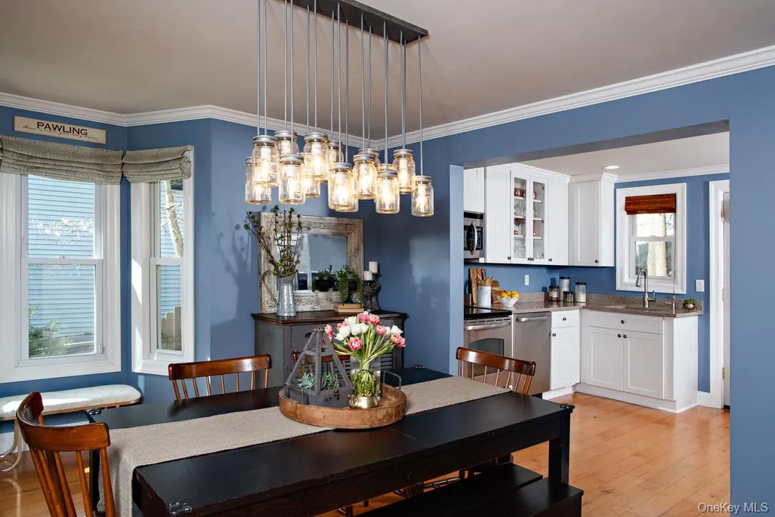 Dining room with light wood finished floors, ornamental molding, and a chandelier Dining room with light wood finished floors, ornamental molding, and a chandelier