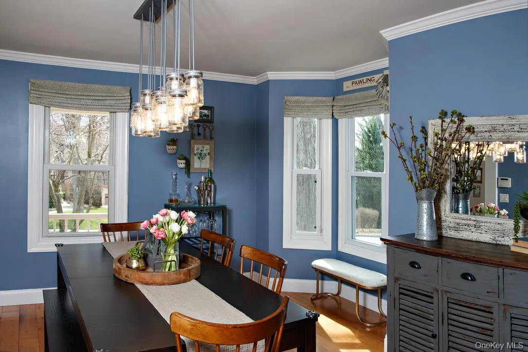 Dining space featuring crown molding, a chandelier, and wood finished floors Dining space featuring crown molding, a chandelier, and wood finished floors