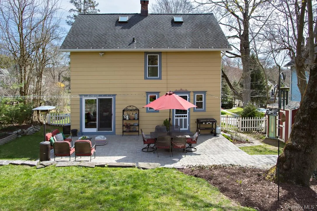 Rear view of property featuring a patio area, roof with shingles, and a chimney Rear view of property featuring a patio area, roof with shingles, and a chimney