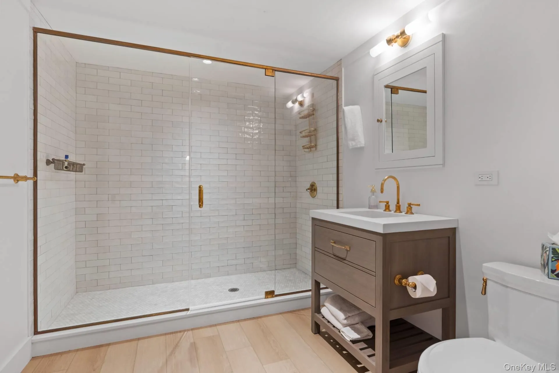 Bathroom with vanity, a shower stall, and light wood-type flooring Bathroom with vanity, a shower stall, and light wood-type flooring