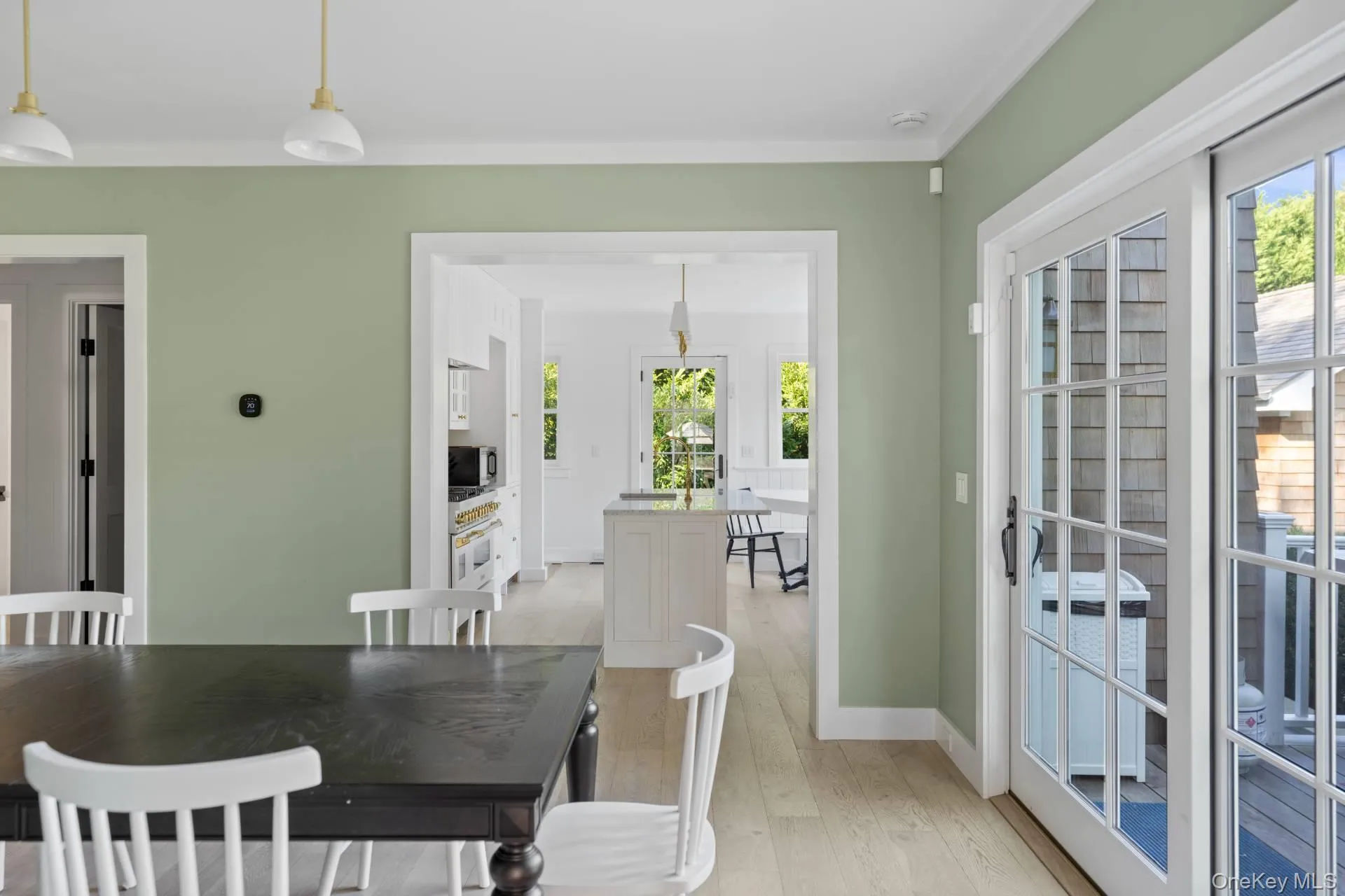 Dining space with light wood-style flooring and ornamental molding Dining space with light wood-style flooring and ornamental molding