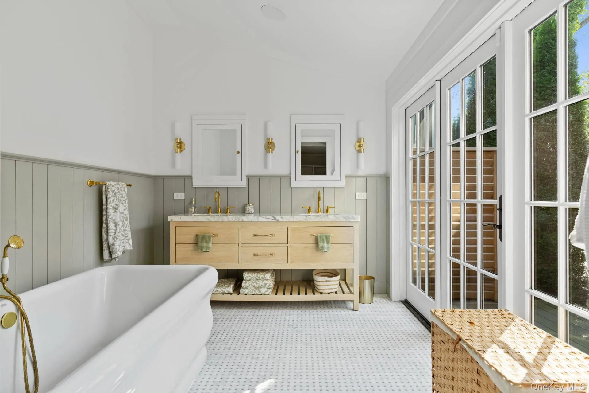 Full bathroom featuring a soaking tub, vaulted ceiling, double vanity, and a wainscoted wall Full bathroom featuring a soaking tub, vaulted ceiling, double vanity, and a wainscoted wall