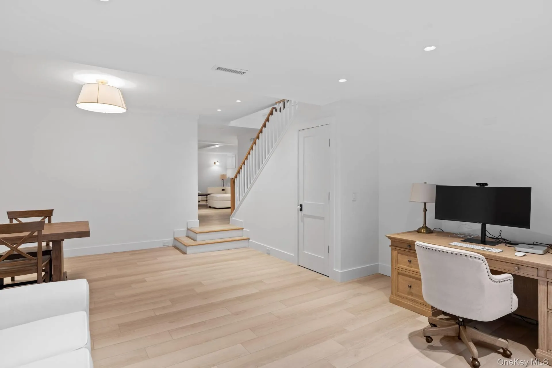 Office with light wood-style floors and recessed lighting Office with light wood-style floors and recessed lighting