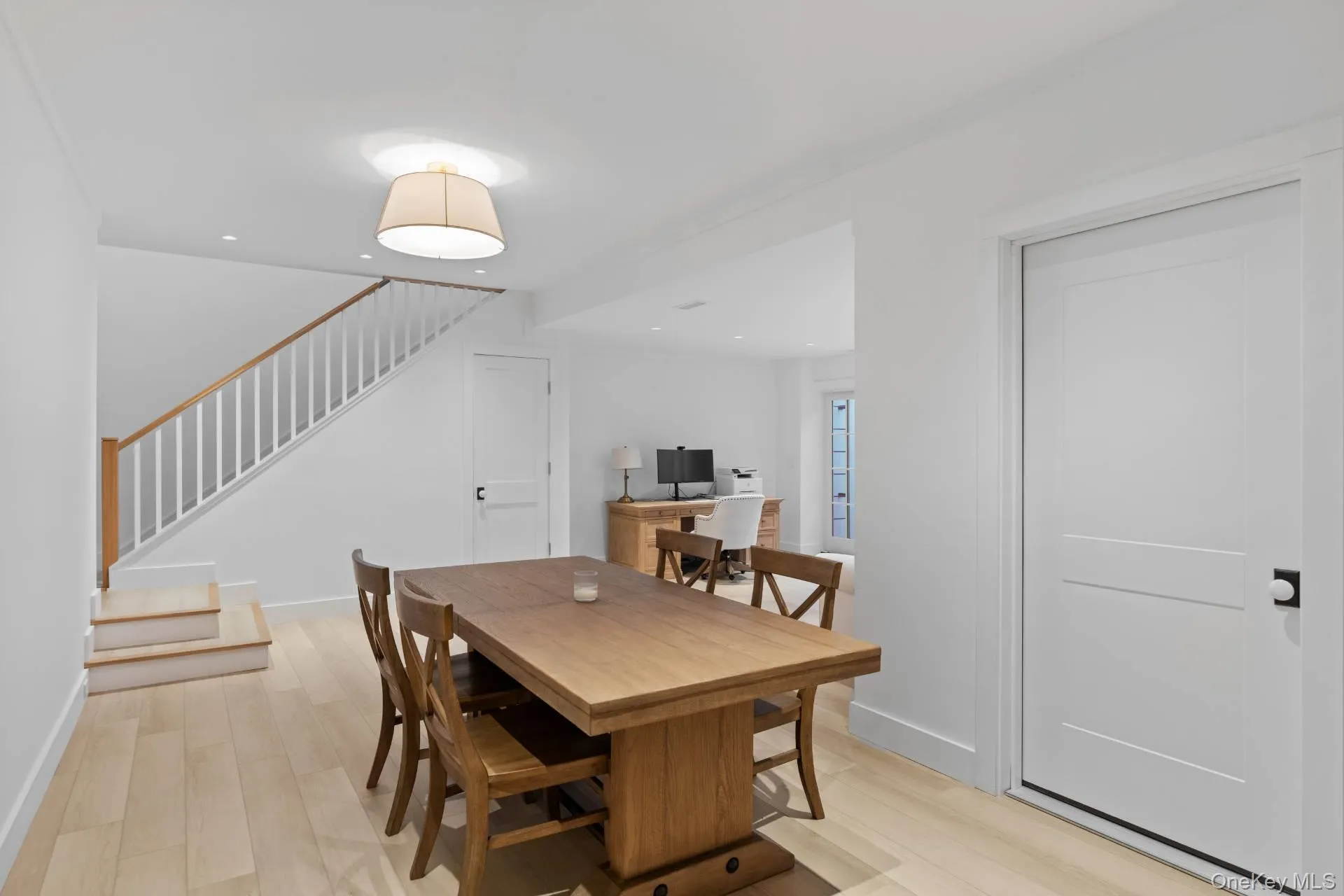 Dining area with light wood-style flooring and stairs Dining area with light wood-style flooring and stairs