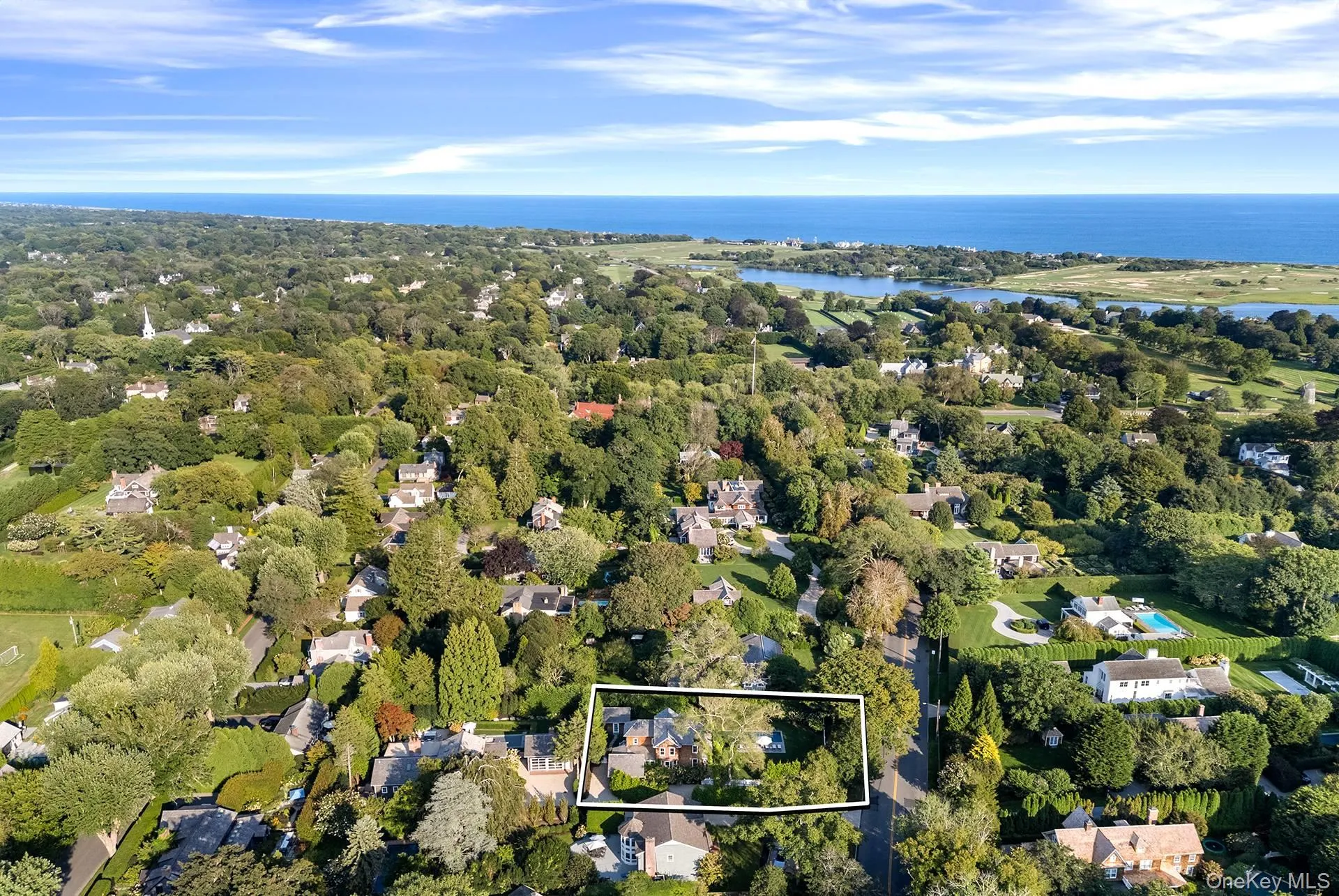 Aerial view of residential area with property parcel outlined and a nearby body of water Aerial view of residential area with property parcel outlined and a nearby body of water