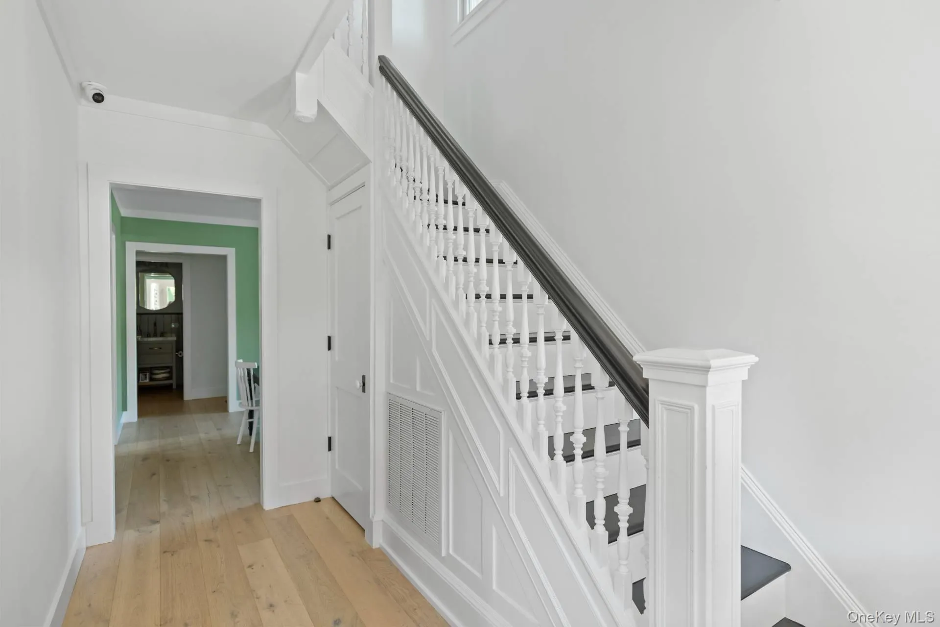 Stairway with hardwood / wood-style flooring, plenty of natural light, and ornamental molding Stairway with hardwood / wood-style flooring, plenty of natural light, and ornamental molding