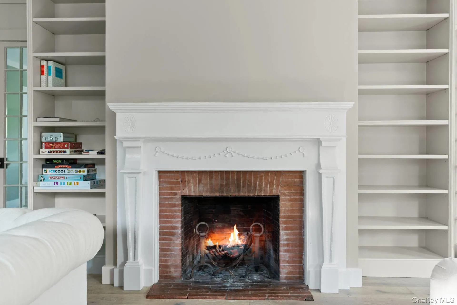 Detailed view of built in shelves, wood finished floors, and a fireplace Detailed view of built in shelves, wood finished floors, and a fireplace