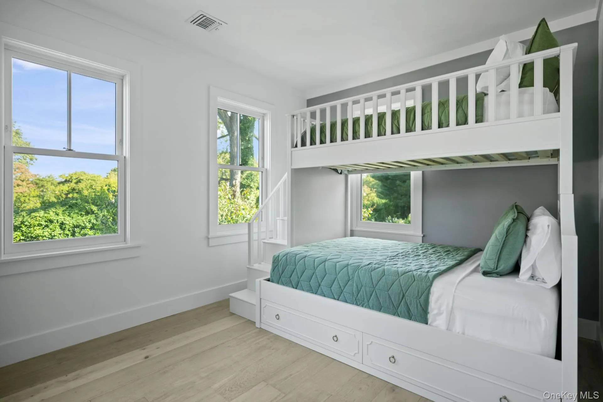 Bedroom featuring wood finished floors and multiple windows Bedroom featuring wood finished floors and multiple windows