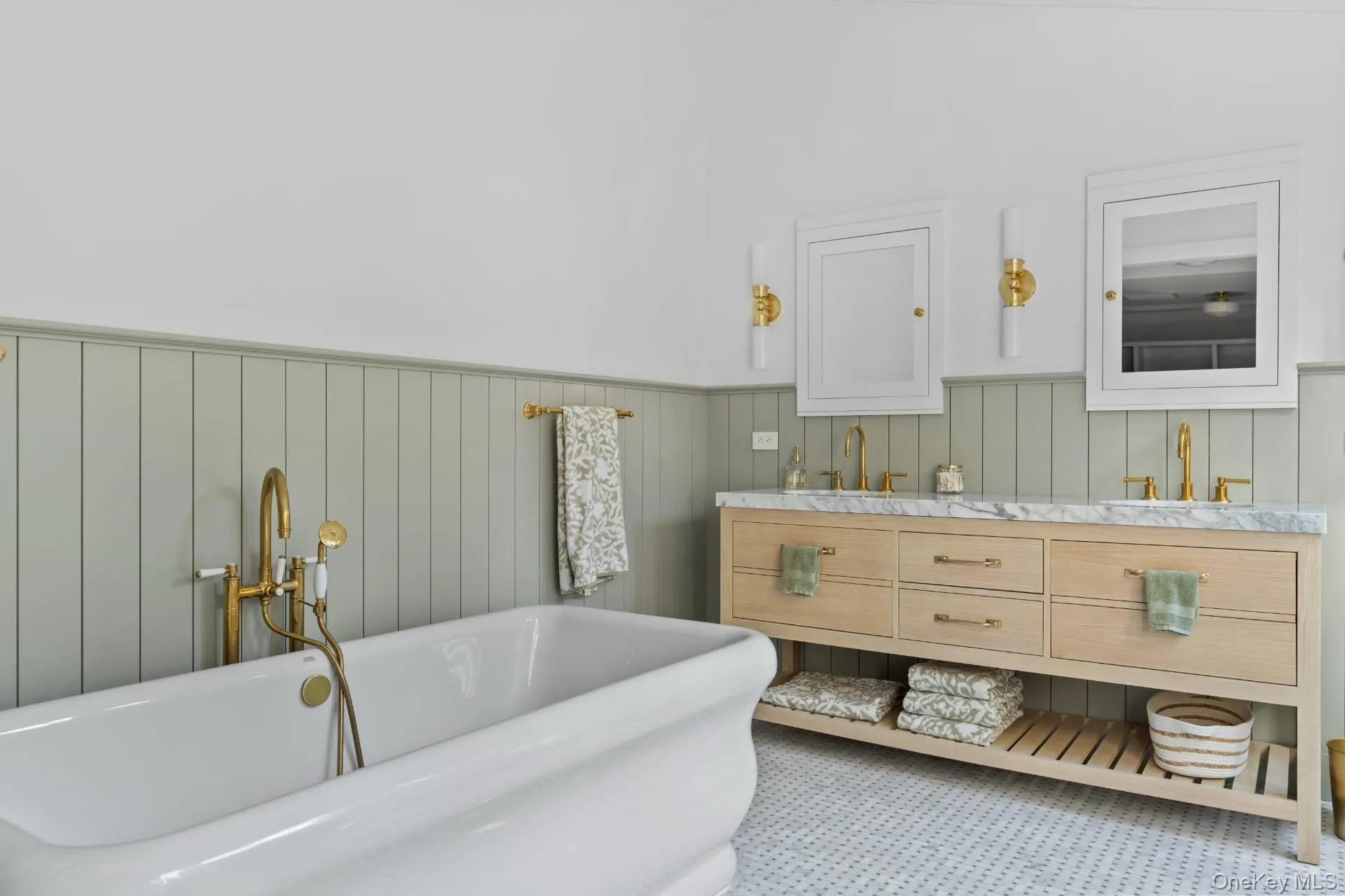 Full bath with double vanity, a freestanding tub, and a wainscoted wall Full bath with double vanity, a freestanding tub, and a wainscoted wall