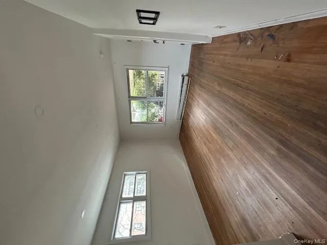Unfurnished room featuring hardwood / wood-style flooring and baseboard heating Unfurnished room featuring hardwood / wood-style flooring and baseboard heating