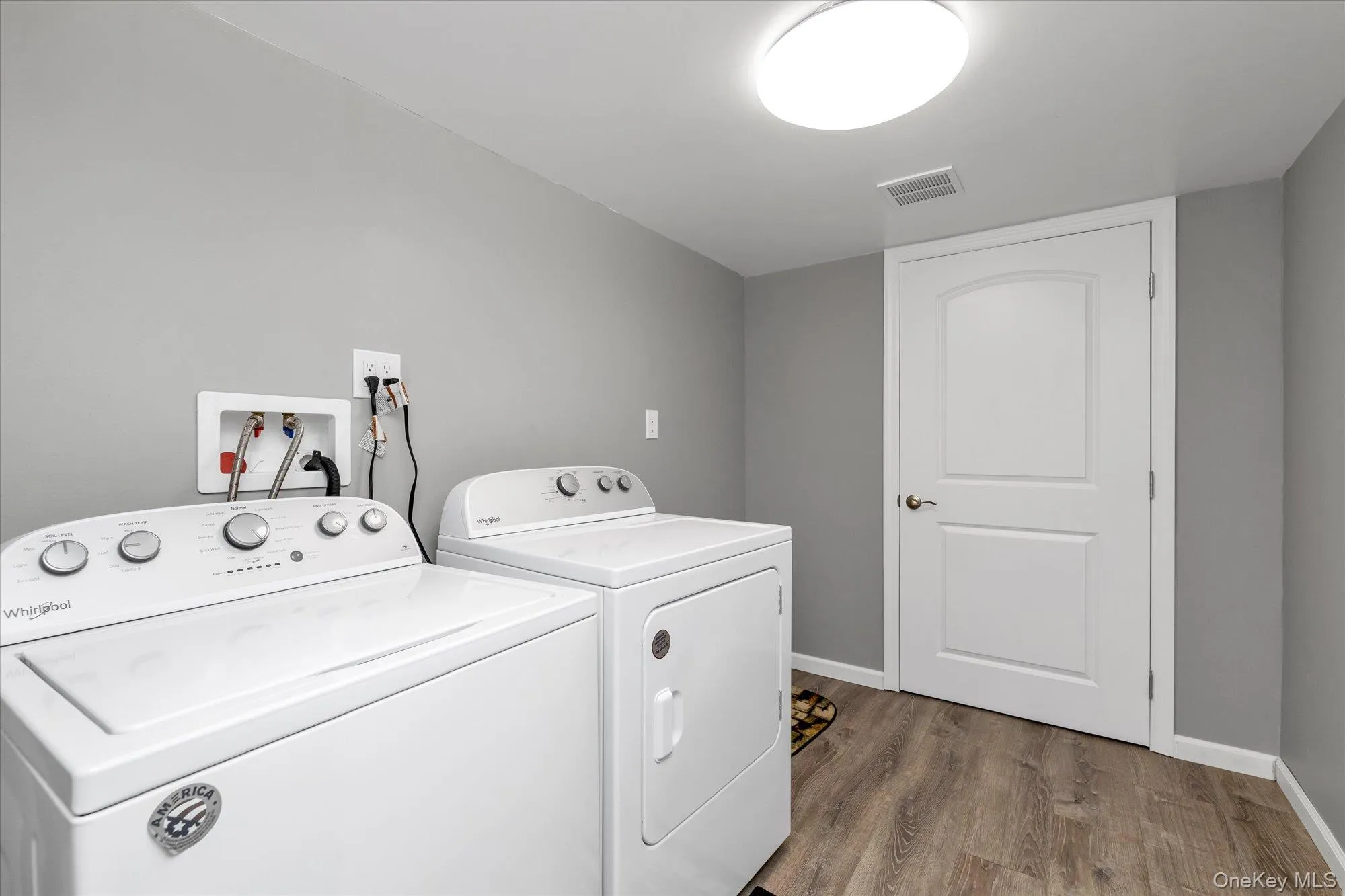 Washroom with dark wood finished floors and washing machine and dryer Washroom with dark wood finished floors and washing machine and dryer