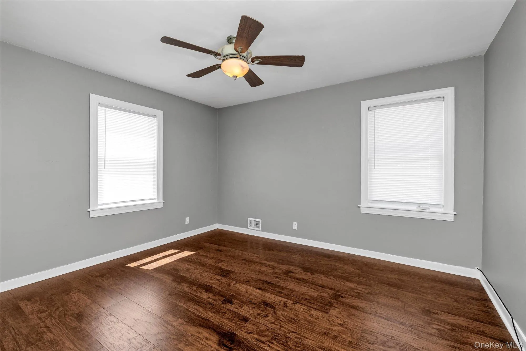 Spare room with dark wood finished floors and ceiling fan Spare room with dark wood finished floors and ceiling fan