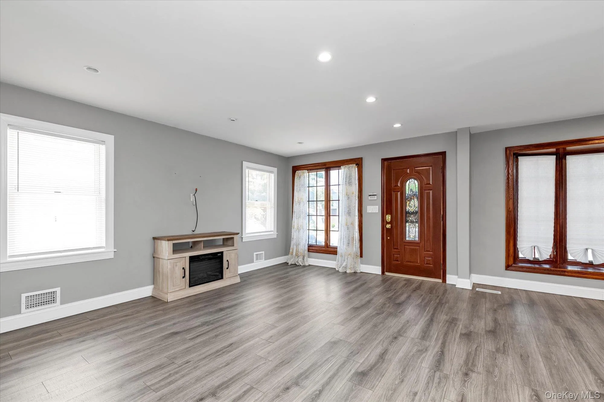 Unfurnished living room with recessed lighting, a fireplace, and wood finished floors Unfurnished living room with recessed lighting, a fireplace, and wood finished floors