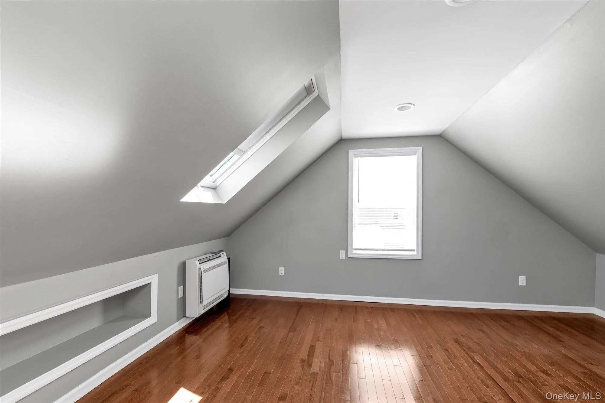 Bonus room with vaulted ceiling, hardwood / wood-style flooring, a skylight, and built in shelves Bonus room with vaulted ceiling, hardwood / wood-style flooring, a skylight, and built in shelves