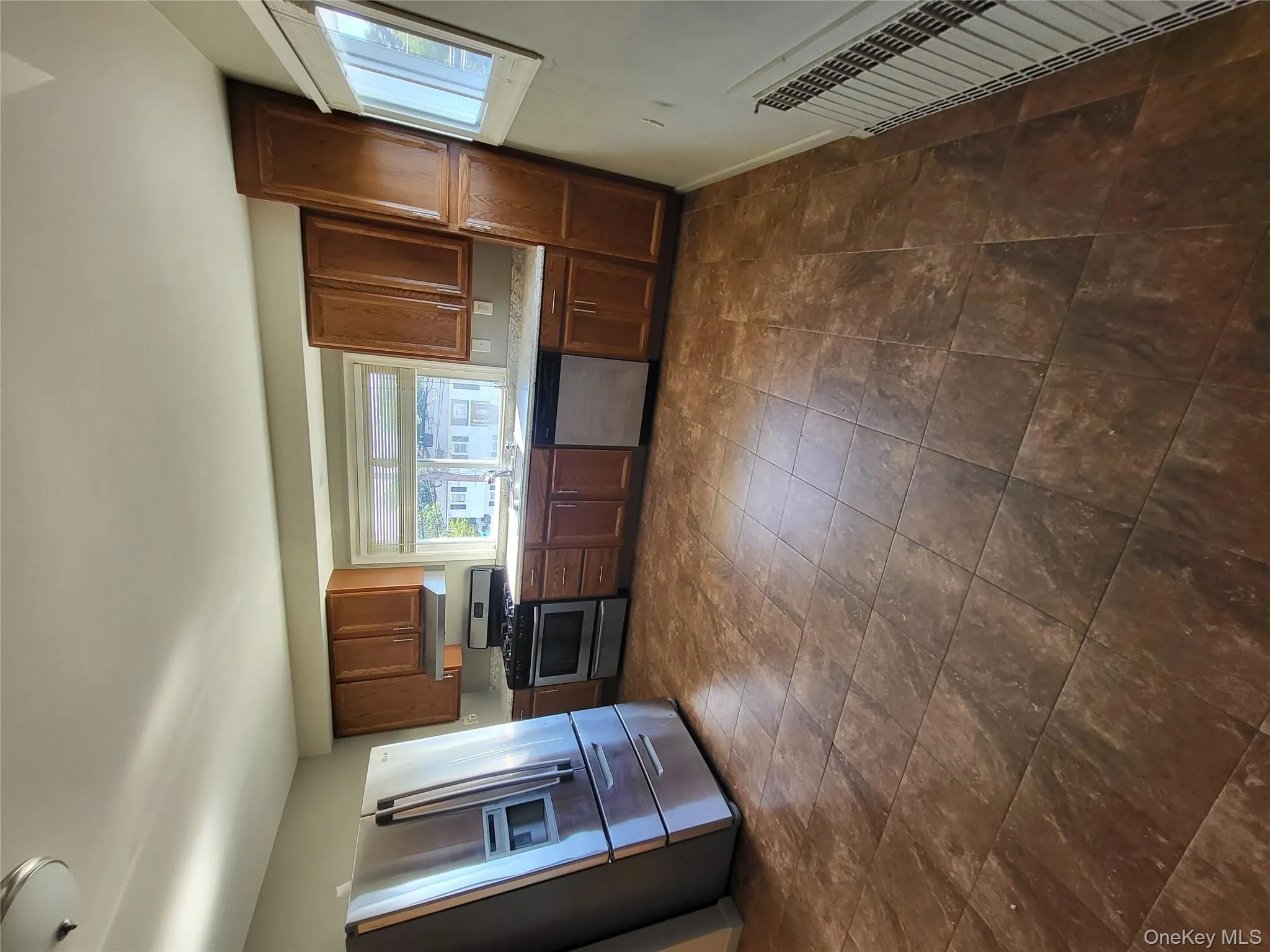 Kitchen featuring fridge, white range oven, dishwashing machine, light countertops, and brown cabinets Kitchen featuring fridge, white range oven, dishwashing machine, light countertops, and brown cabinets