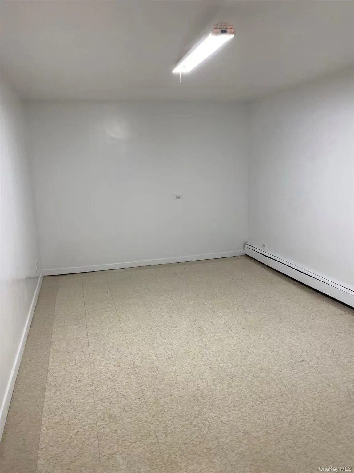 Unfurnished room with light flooring and baseboard heating Unfurnished room with light flooring and baseboard heating