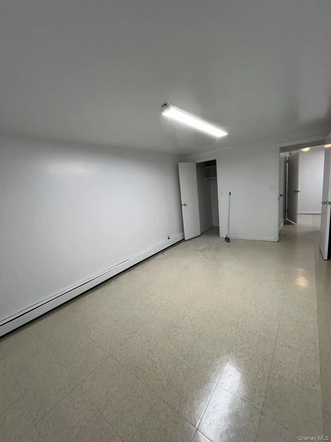 Spare room featuring a baseboard heating unit and light flooring Spare room featuring a baseboard heating unit and light flooring