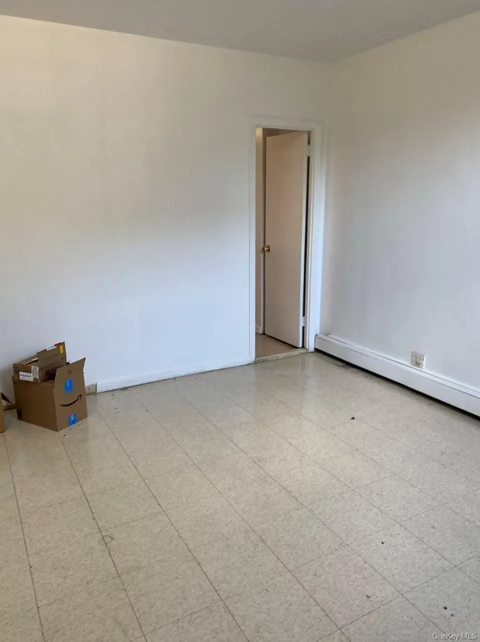 Spare room with a baseboard radiator and light floors Spare room with a baseboard radiator and light floors