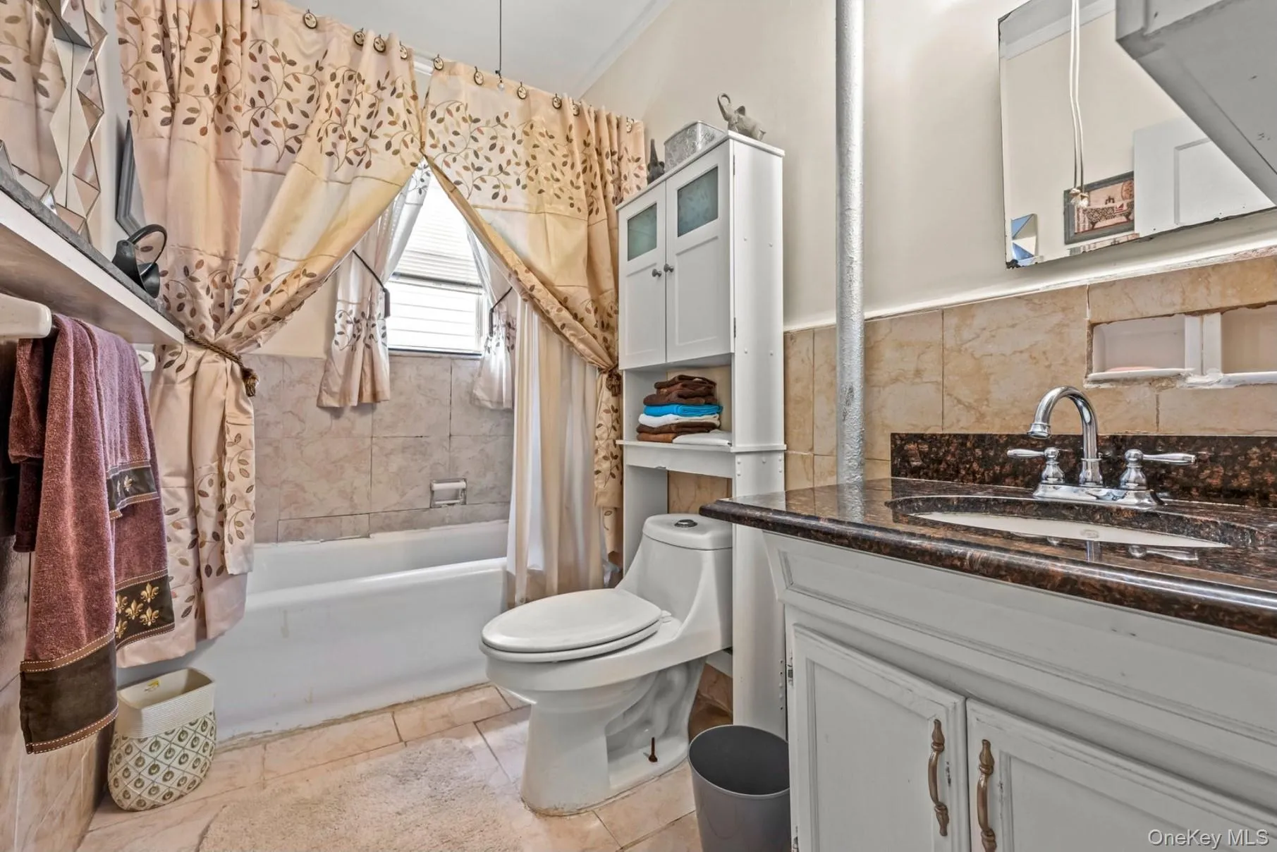 Full bath featuring shower / bath combo, vanity, and light tile patterned floors Full bath featuring shower / bath combo, vanity, and light tile patterned floors