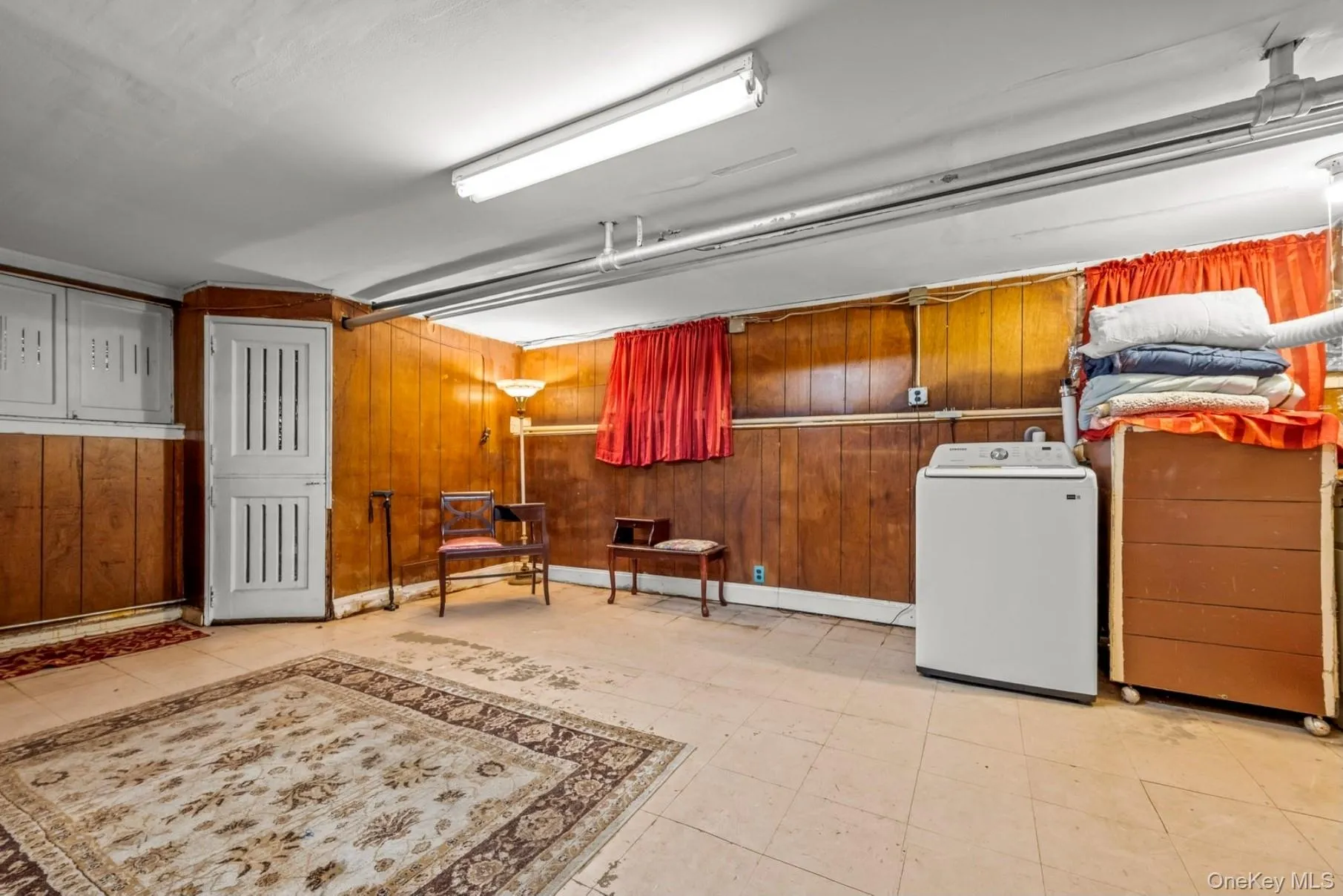 Basement featuring washer / dryer and wood walls Basement featuring washer / dryer and wood walls