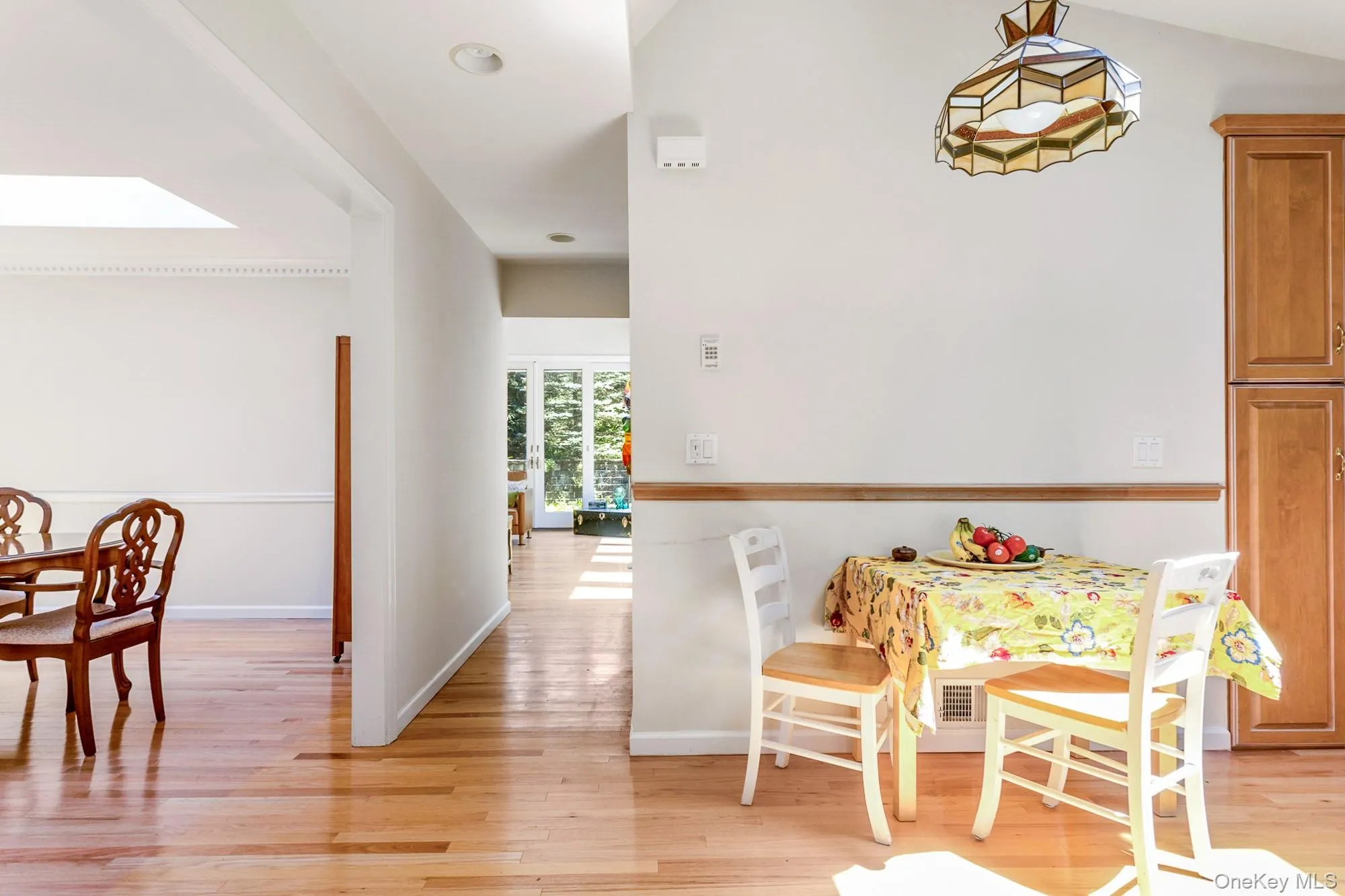 Dining room with light wood finished floors and a skylight Dining room with light wood finished floors and a skylight