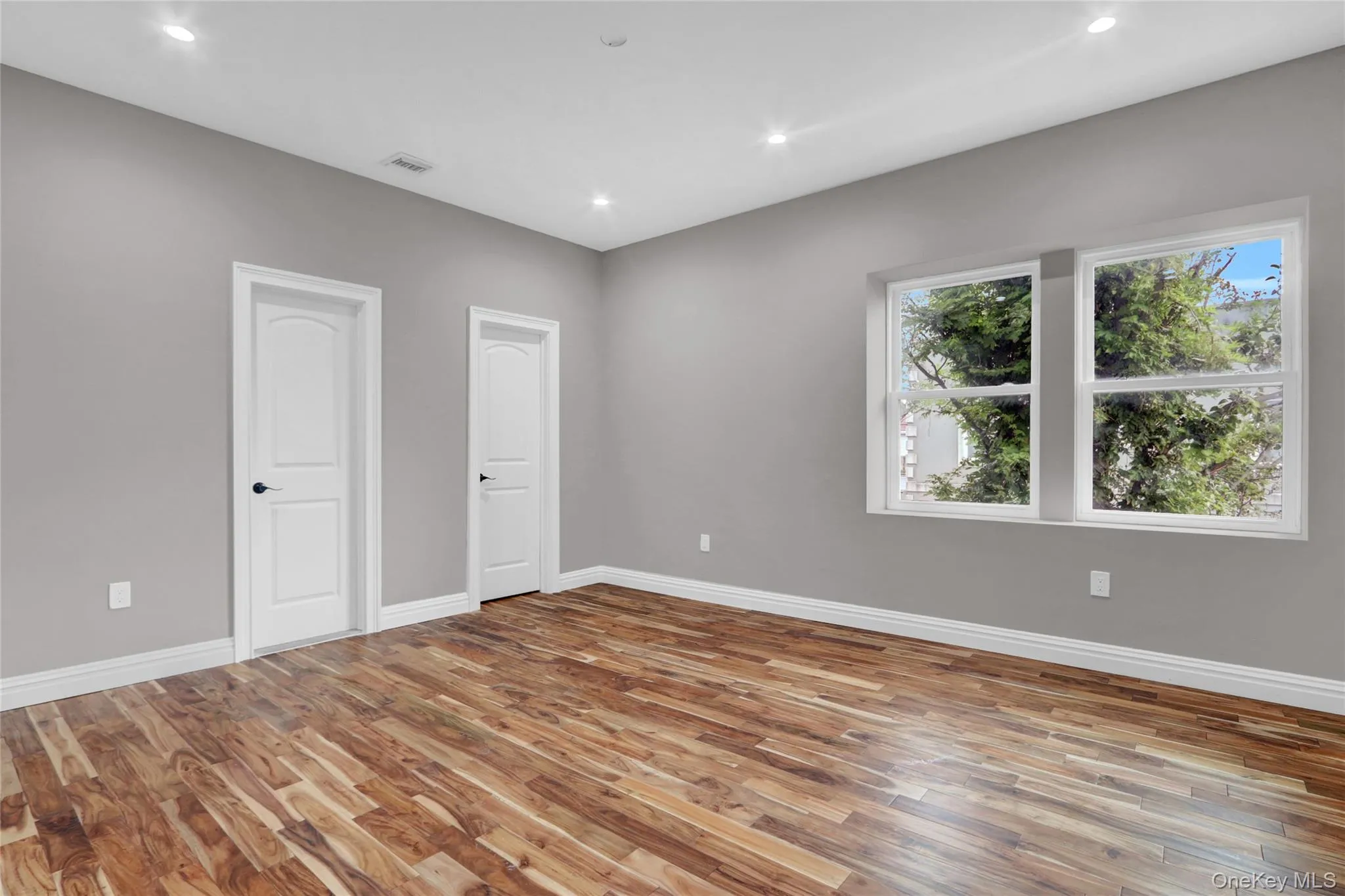 Unfurnished bedroom with light wood finished floors and recessed lighting Unfurnished bedroom with light wood finished floors and recessed lighting