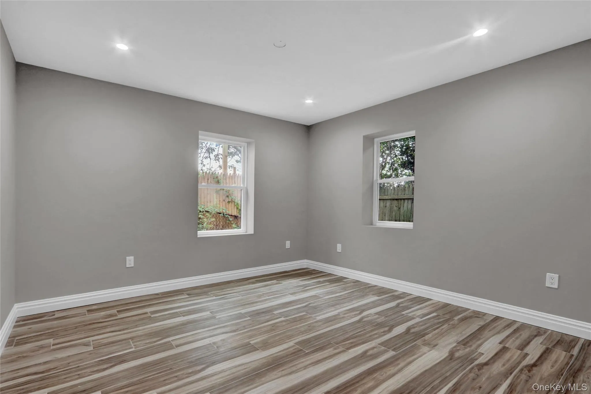 Empty room with light wood-style flooring, recessed lighting, and healthy amount of natural light Empty room with light wood-style flooring, recessed lighting, and healthy amount of natural light