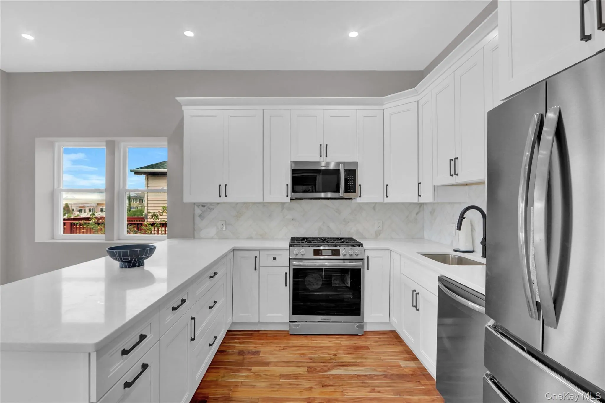 Kitchen featuring appliances with stainless steel finishes, light stone countertops, white cabinetry, and recessed lighting Kitchen featuring appliances with stainless steel finishes, light stone countertops, white cabinetry, and recessed lighting