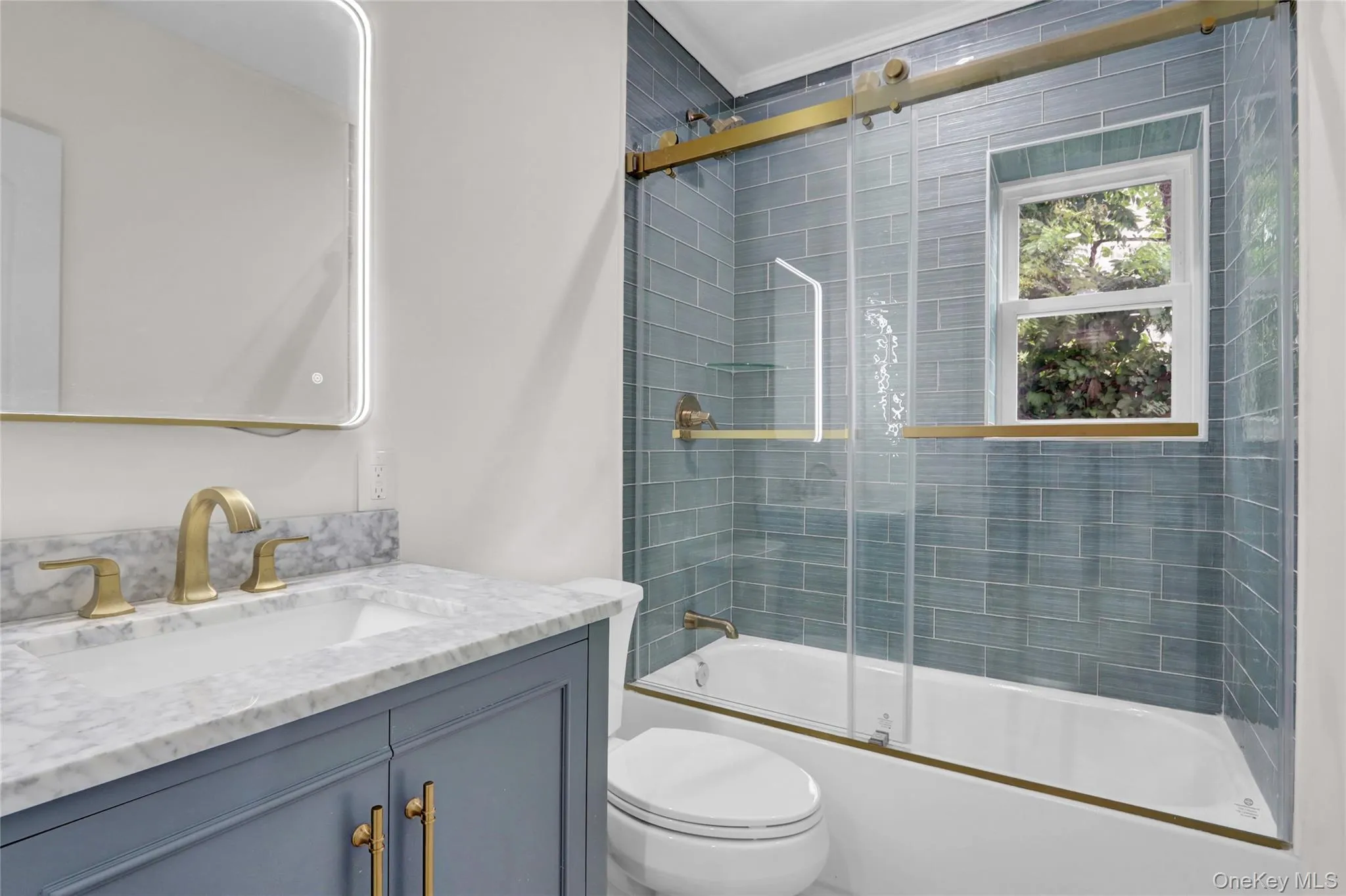 Bathroom featuring vanity and combined bath / shower with glass door Bathroom featuring vanity and combined bath / shower with glass door