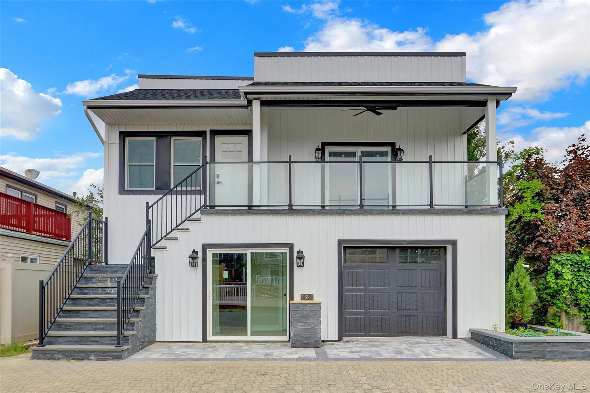 View of front of property with ceiling fan, stairway, an attached garage, and a balcony View of front of property with ceiling fan, stairway, an attached garage, and a balcony