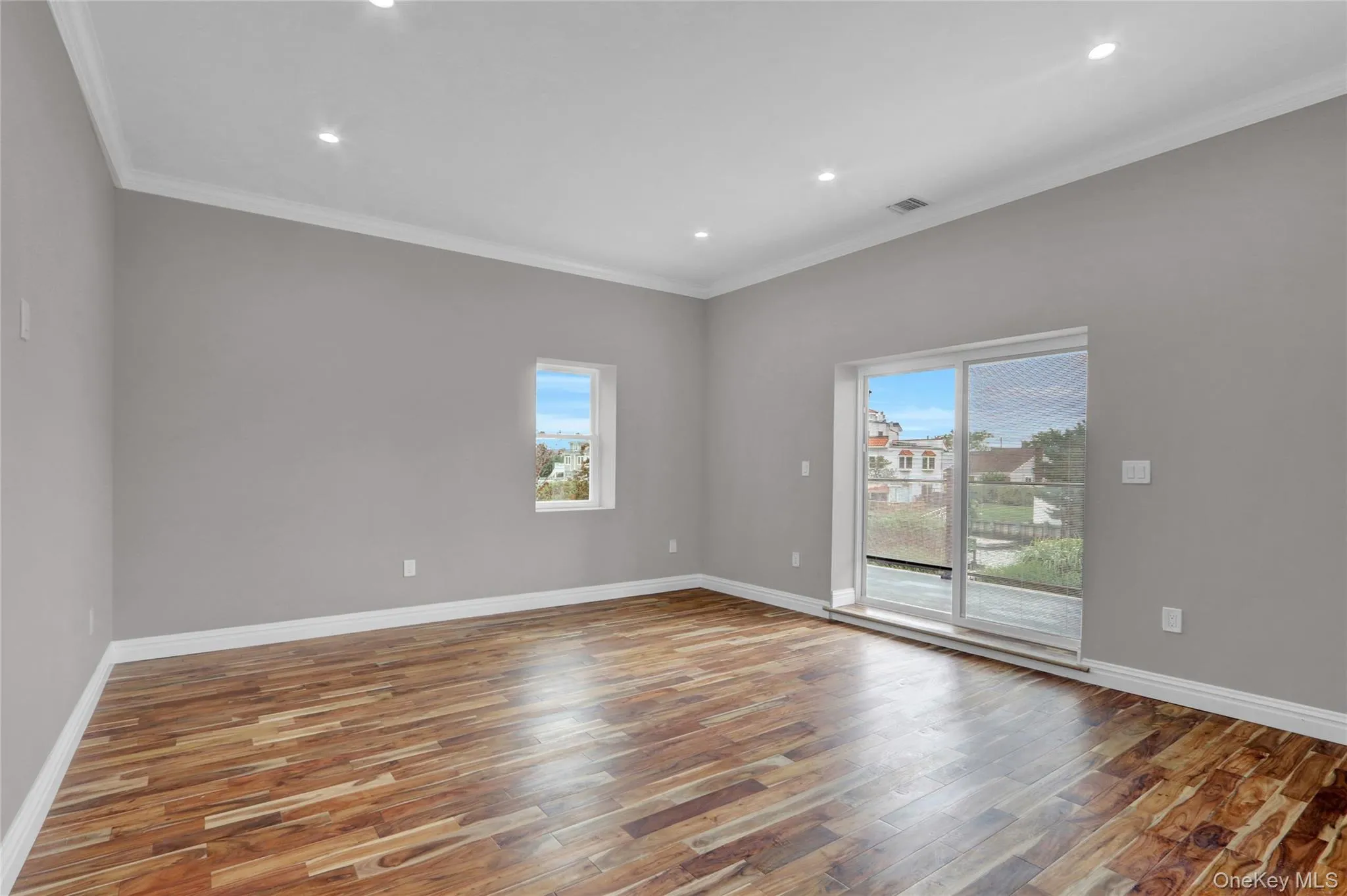 Empty room featuring ornamental molding, light wood finished floors, plenty of natural light, and recessed lighting Empty room featuring ornamental molding, light wood finished floors, plenty of natural light, and recessed lighting