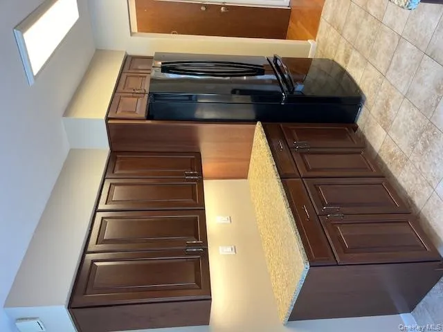 Kitchen with refrigerator, light stone counters, dark brown cabinets, and light tile patterned floors Kitchen with refrigerator, light stone counters, dark brown cabinets, and light tile patterned floors