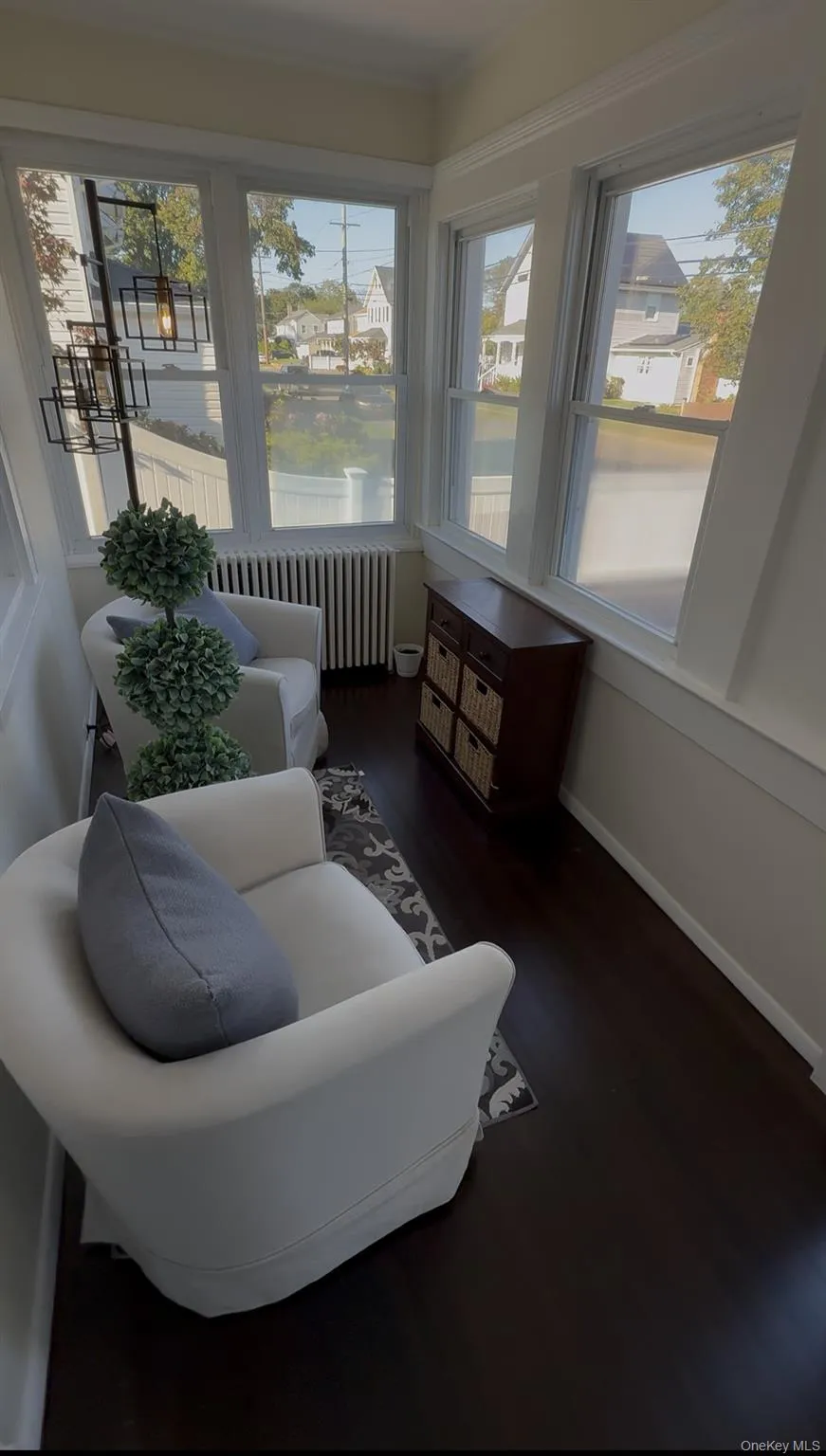 Sunroom featuring wood finished floors and radiator Sunroom featuring wood finished floors and radiator