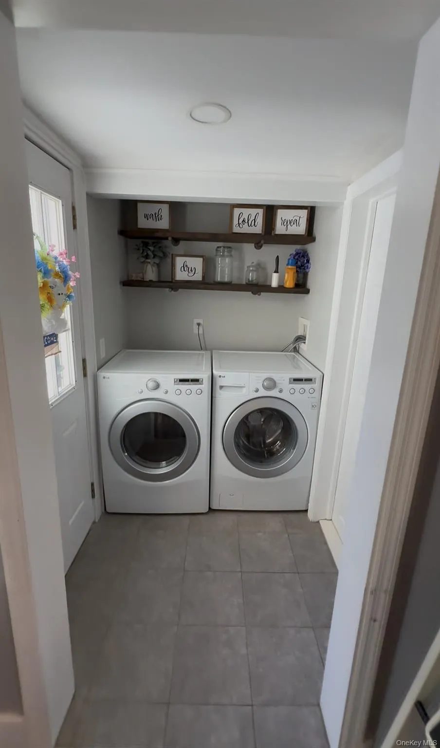 Laundry area featuring dark tile patterned flooring and washer and dryer Laundry area featuring dark tile patterned flooring and washer and dryer