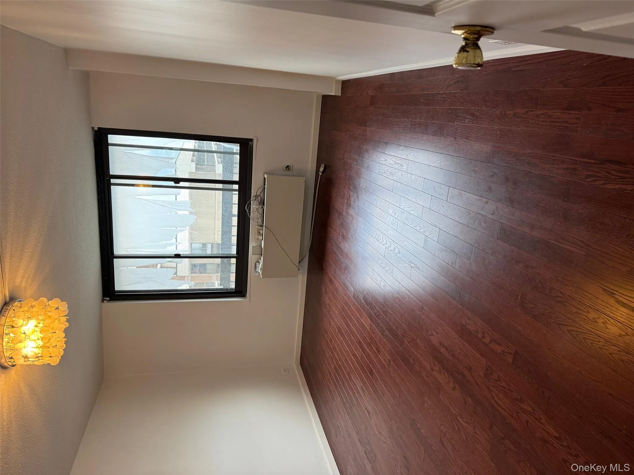 Spare room featuring dark wood-style floors, a textured ceiling, and a chandelier Spare room featuring dark wood-style floors, a textured ceiling, and a chandelier