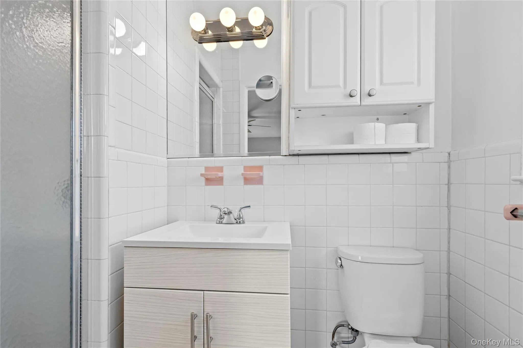 Full bathroom with tile walls, vanity, and a stall shower Full bathroom with tile walls, vanity, and a stall shower