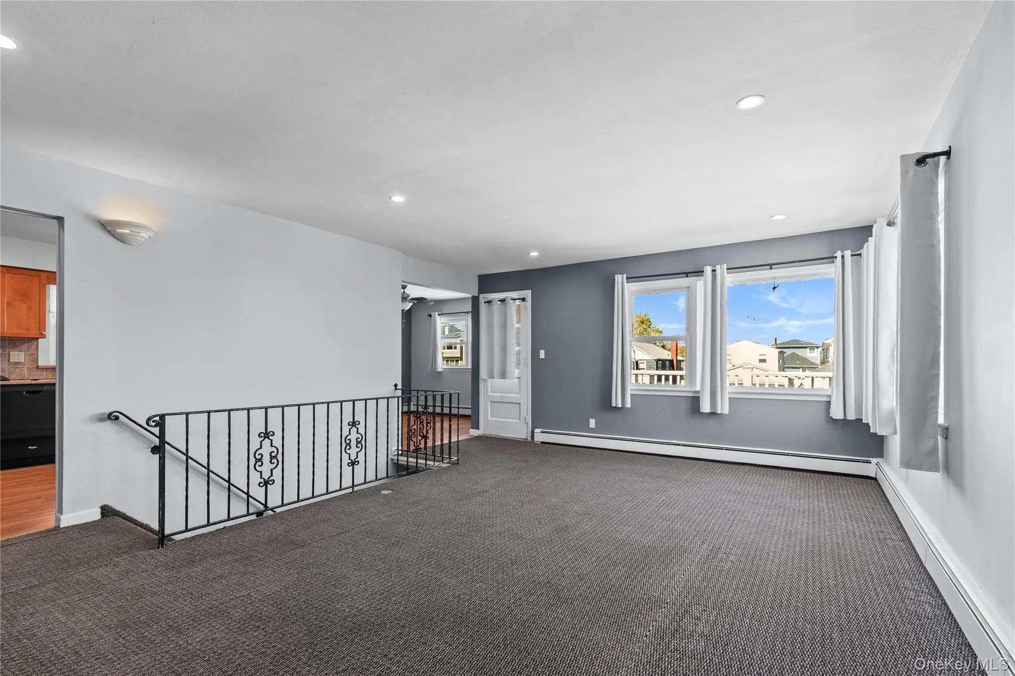 Empty room featuring baseboard heating, recessed lighting, and dark carpet Empty room featuring baseboard heating, recessed lighting, and dark carpet