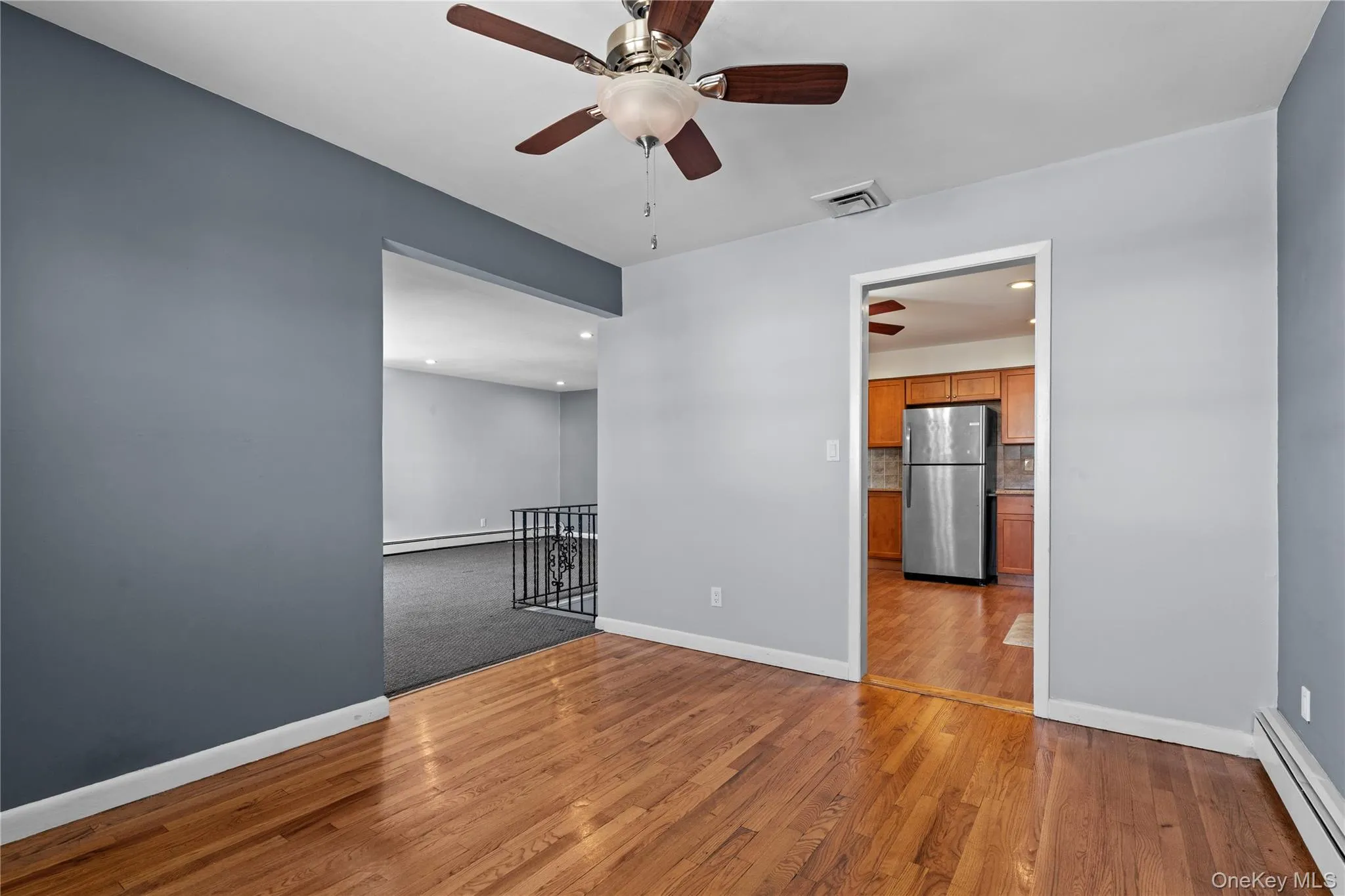 Unfurnished room with baseboard heating, light wood-style floors, recessed lighting, and a ceiling fan Unfurnished room with baseboard heating, light wood-style floors, recessed lighting, and a ceiling fan