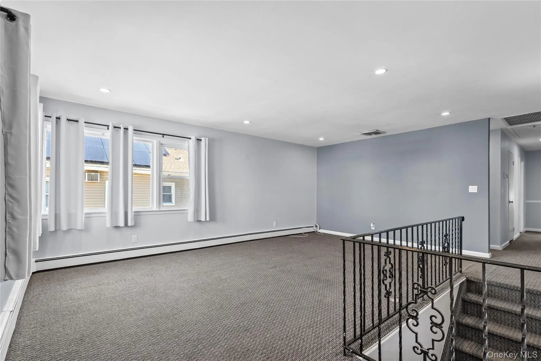 Empty room featuring carpet floors, baseboard heating, and recessed lighting Empty room featuring carpet floors, baseboard heating, and recessed lighting