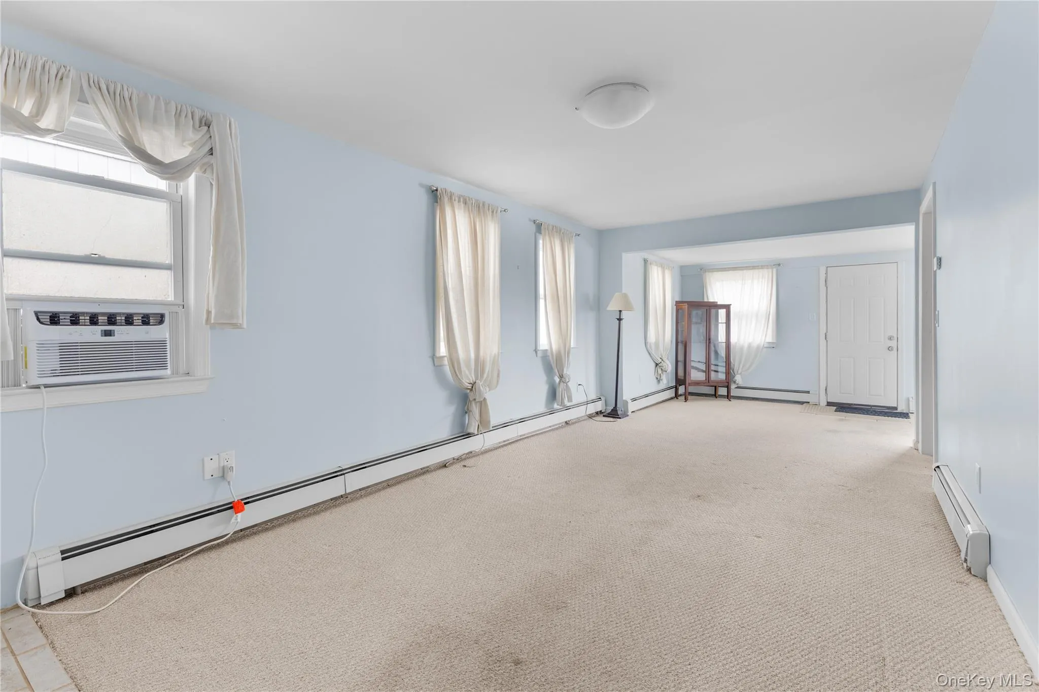 Spare room with baseboard heating, healthy amount of natural light, and carpet Spare room with baseboard heating, healthy amount of natural light, and carpet