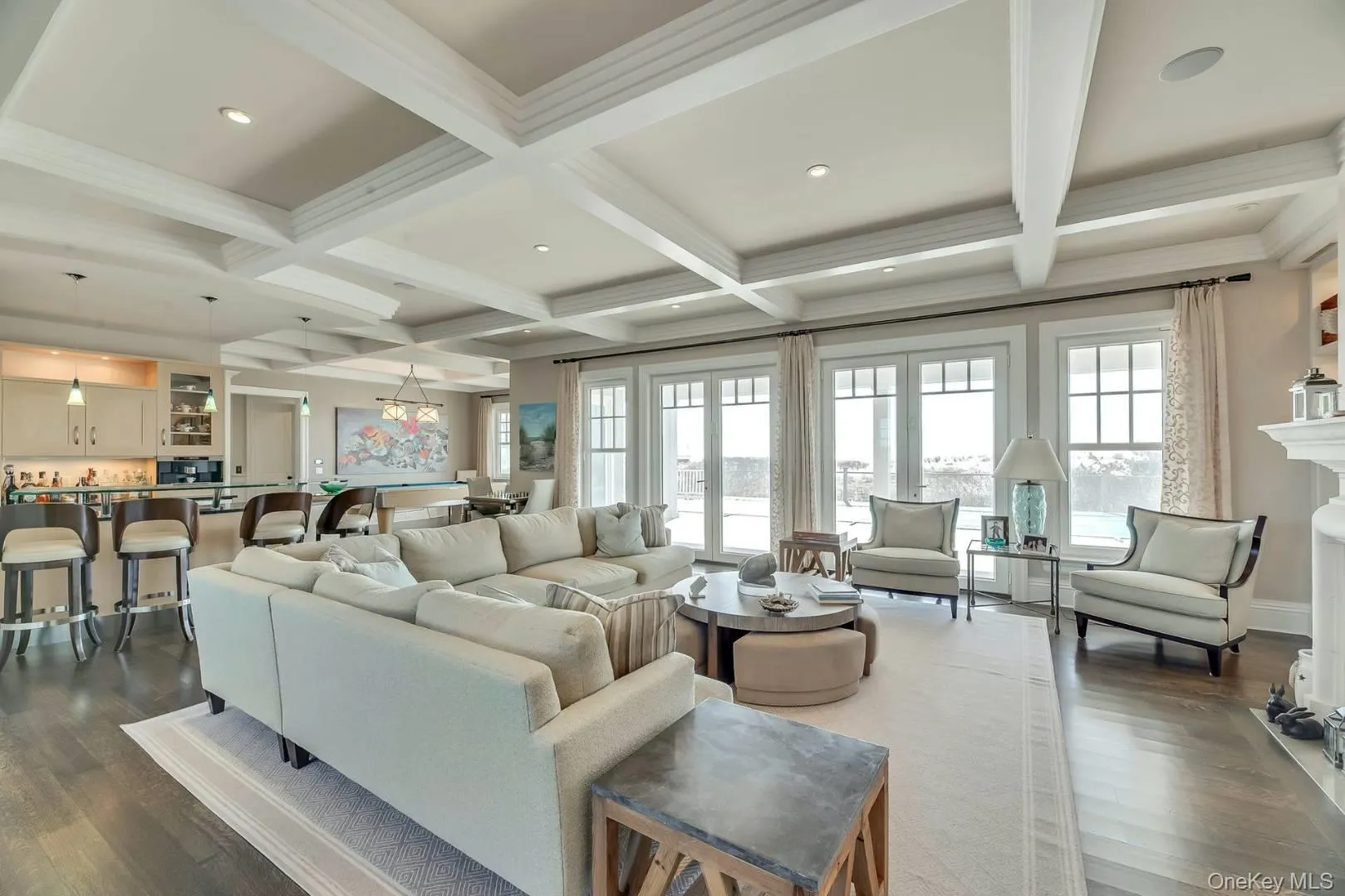 Living area featuring beam ceiling, wood-style floors, coffered ceiling, recessed lighting, and ornamental molding Living area featuring beam ceiling, wood-style floors, coffered ceiling, recessed lighting, and ornamental molding