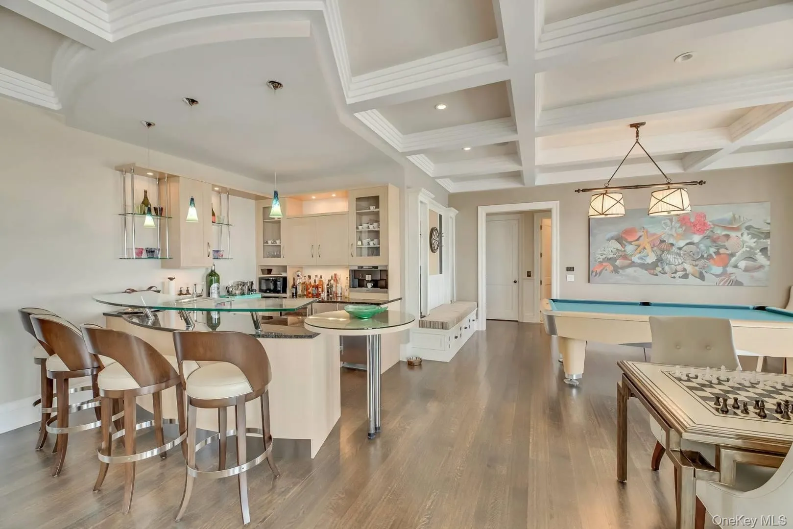 Indoor wet bar with decorative light fixtures, beam ceiling, coffered ceiling, glass insert cabinets, and dark wood-type flooring Indoor wet bar with decorative light fixtures, beam ceiling, coffered ceiling, glass insert cabinets, and dark wood-type flooring