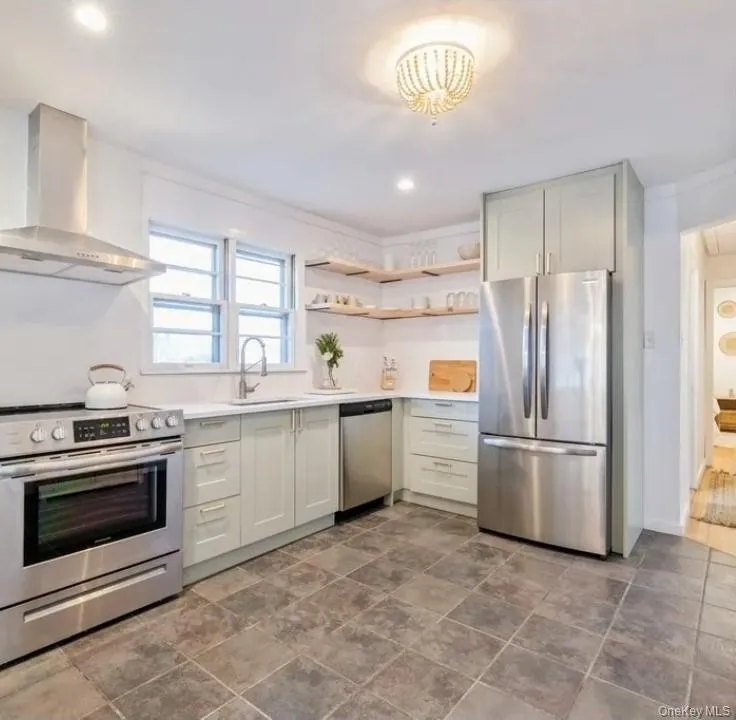 Kitchen featuring stainless steel appliances, open shelves, wall chimney range hood, and recessed lighting Kitchen featuring stainless steel appliances, open shelves, wall chimney range hood, and recessed lighting