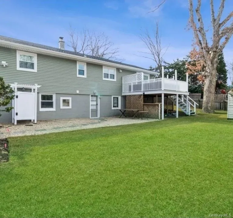 Rear view of house featuring a deck, stairs, and a chimney Rear view of house featuring a deck, stairs, and a chimney