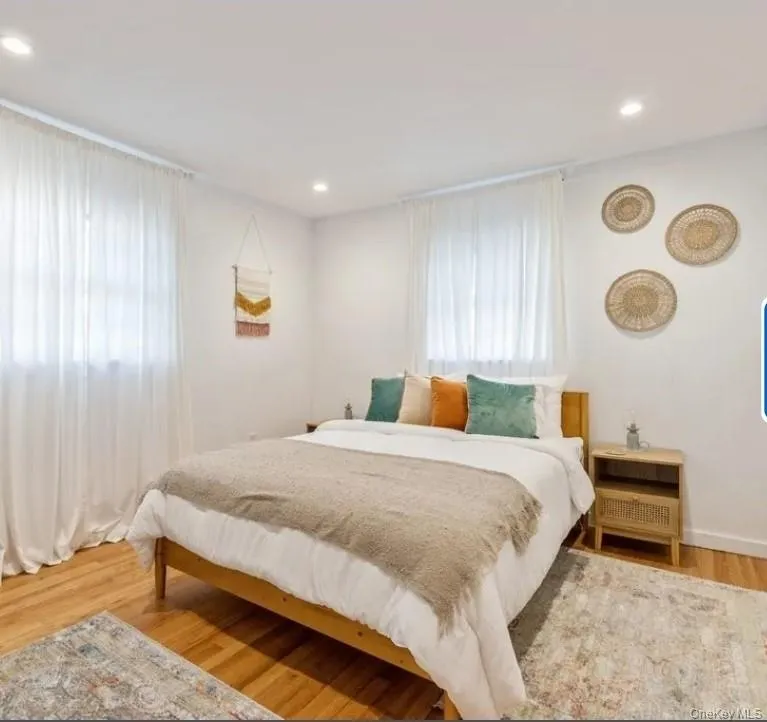 Bedroom featuring light wood-style flooring, multiple windows, and recessed lighting Bedroom featuring light wood-style flooring, multiple windows, and recessed lighting