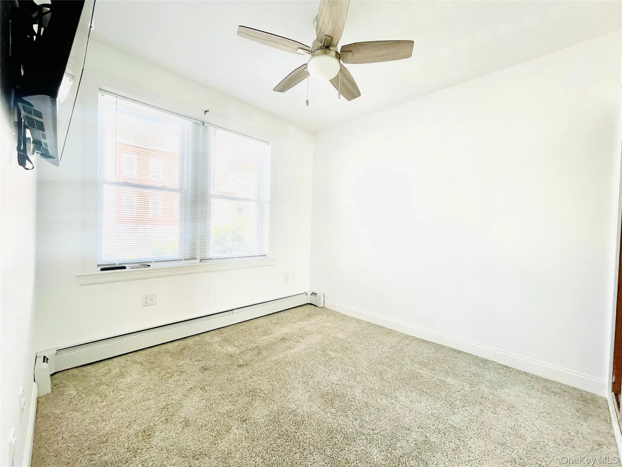 Spare room featuring a baseboard heating unit, carpet, and a ceiling fan Spare room featuring a baseboard heating unit, carpet, and a ceiling fan