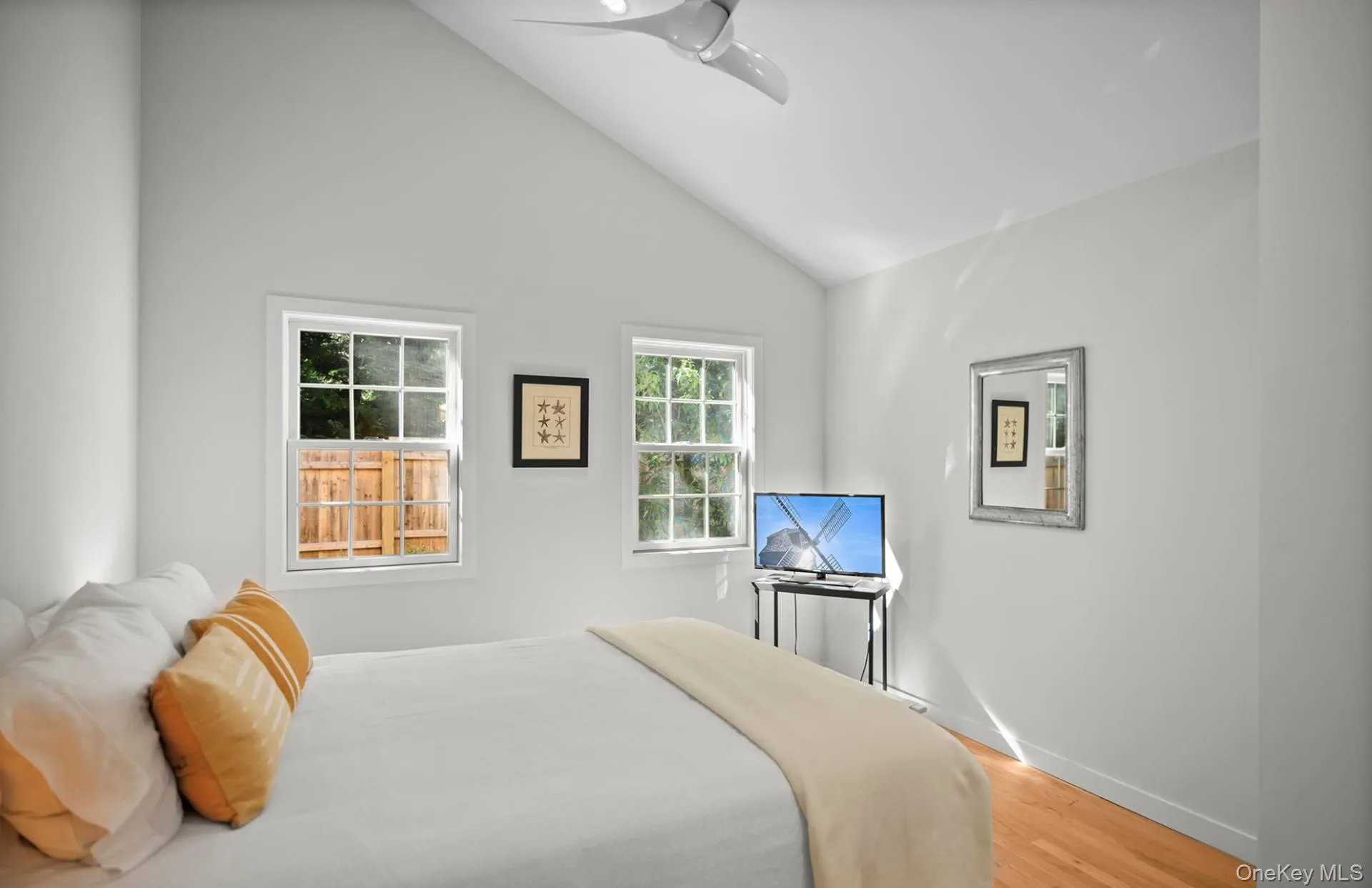 Bedroom featuring light wood-style floors, a ceiling fan, and high vaulted ceiling Bedroom featuring light wood-style floors, a ceiling fan, and high vaulted ceiling