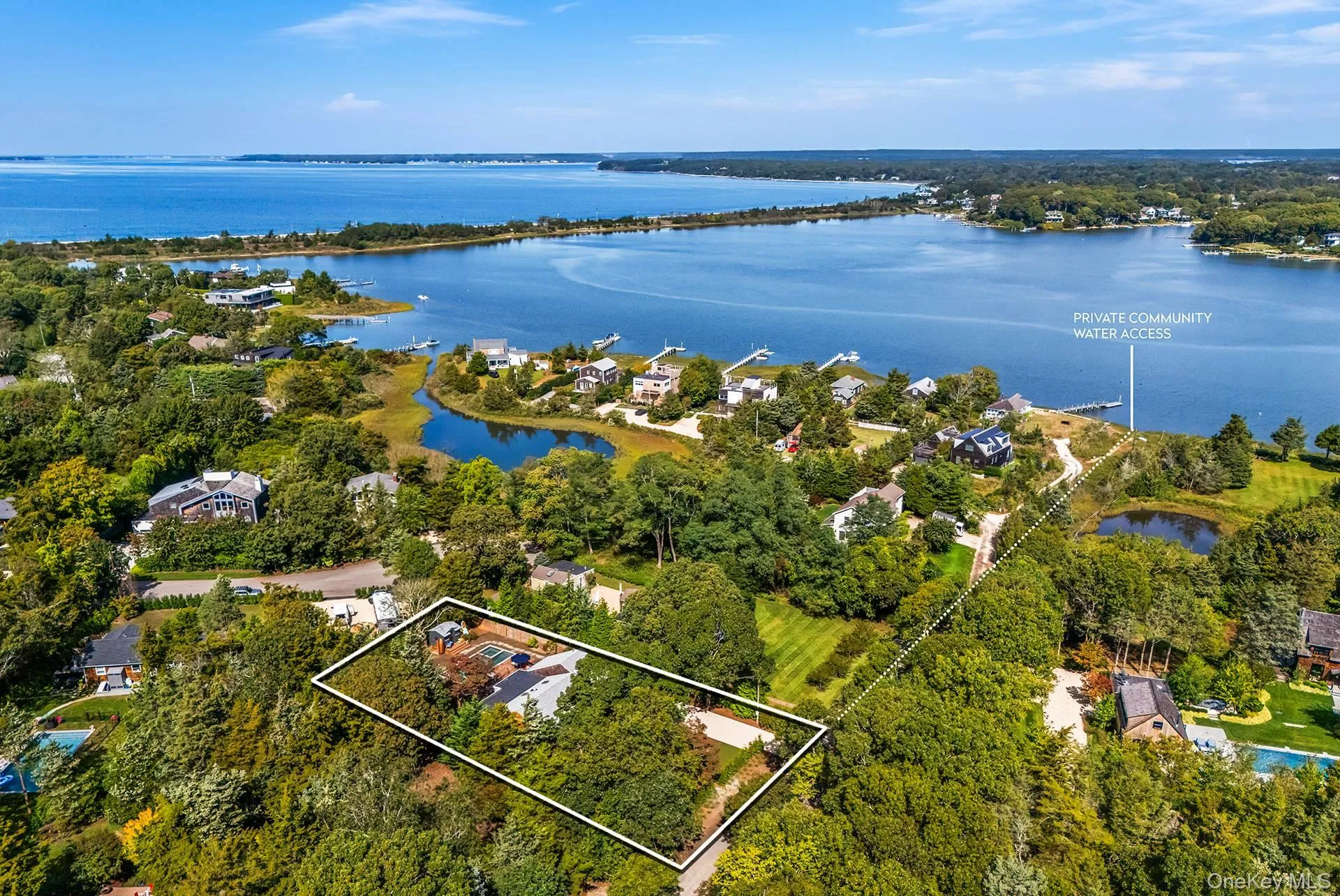 Aerial perspective of suburban area featuring property boundaries highlighted and a nearby body of water Aerial perspective of suburban area featuring property boundaries highlighted and a nearby body of water
