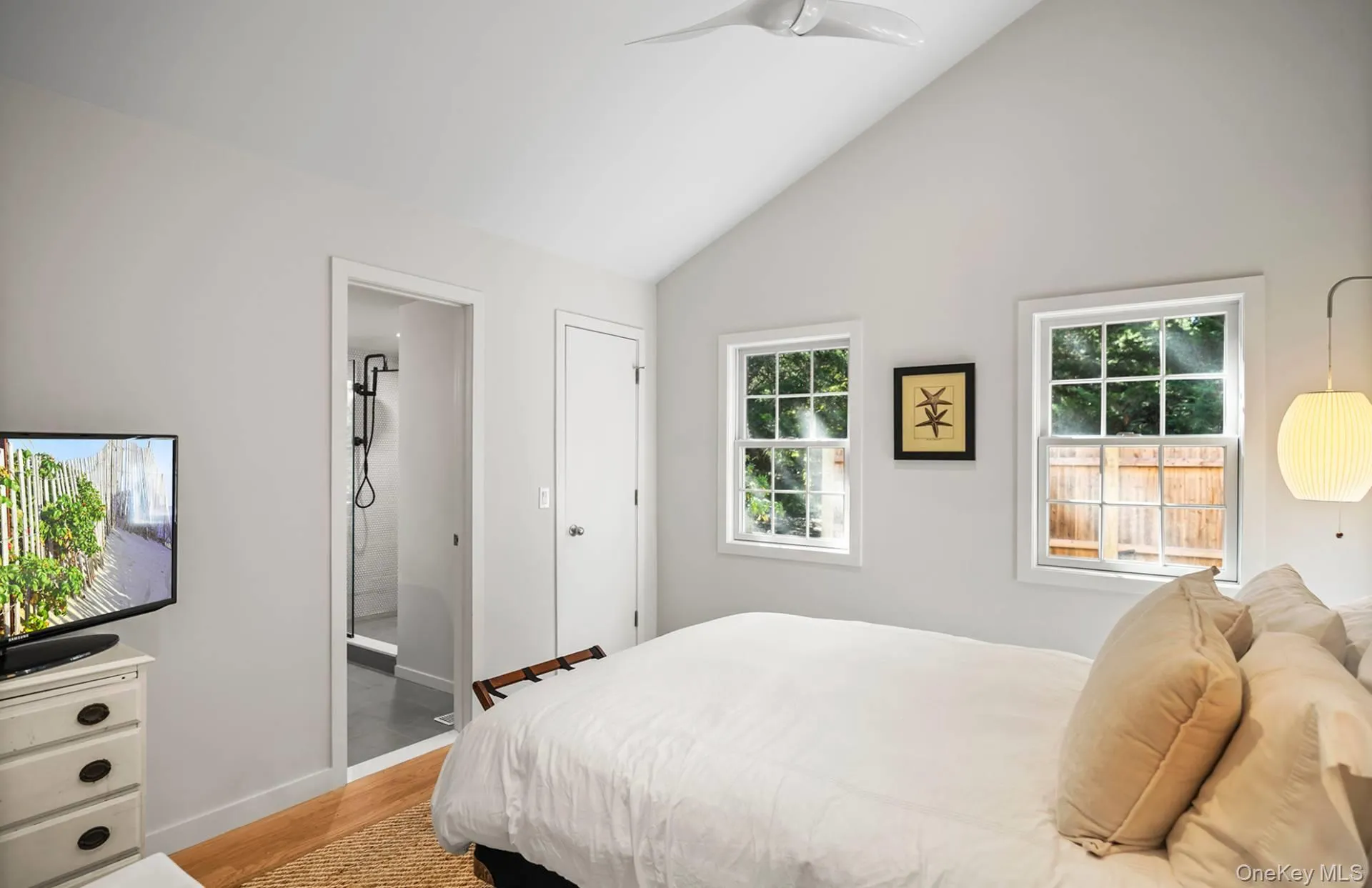 Bedroom with light wood-style flooring, ceiling fan, connected bathroom, and high vaulted ceiling Bedroom with light wood-style flooring, ceiling fan, connected bathroom, and high vaulted ceiling